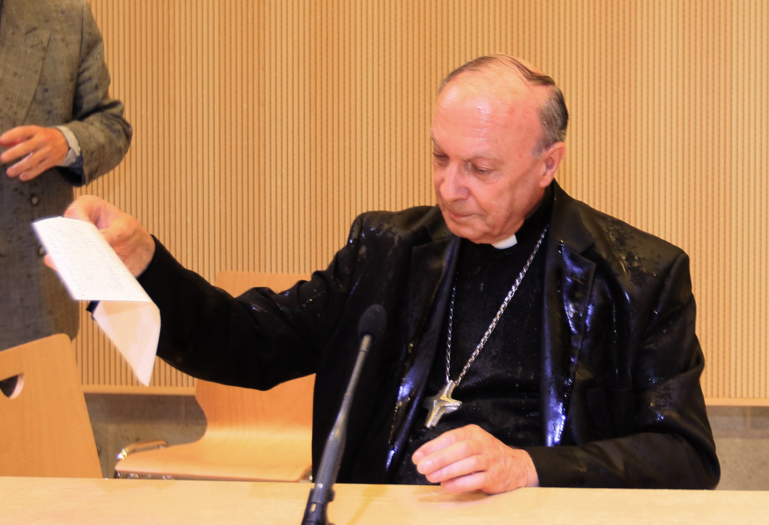Belgian Archbishop of Mechelen-Brussels and Primate of Belgium Leonard reacts after activists from women's rights group Femen sprayed water at him during a conference at Brussels university ULB